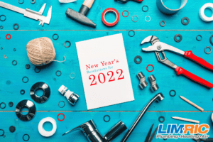 Plumbing tools surrounding papers with words "New Year's Resolutions for 2022" printed on it.